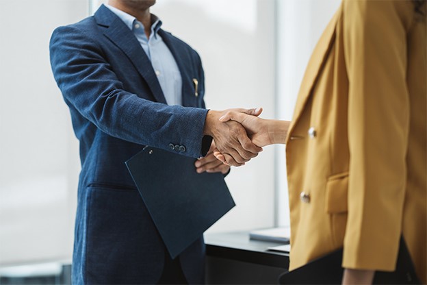 Male and female office professionals shaking hands
