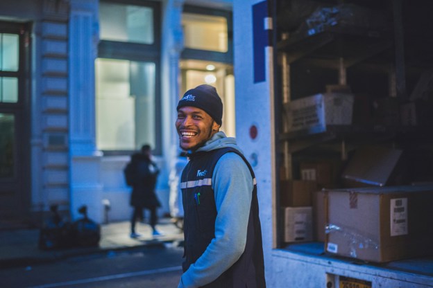 Delivery driver smiling next to his truck