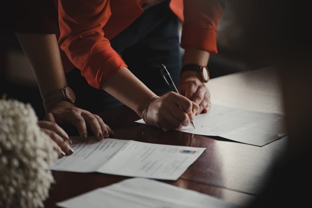 Person signing a document on a table