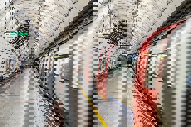 London underground platform with train moving nearby