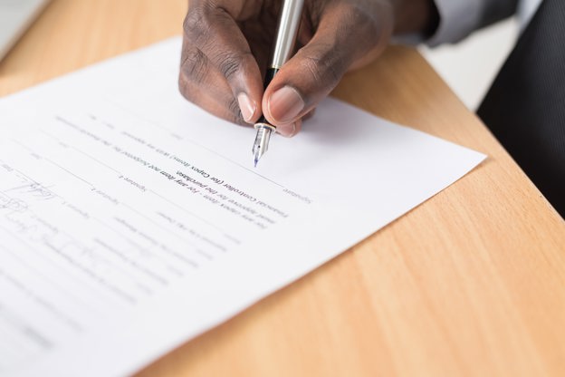 Person signing a piece of paper