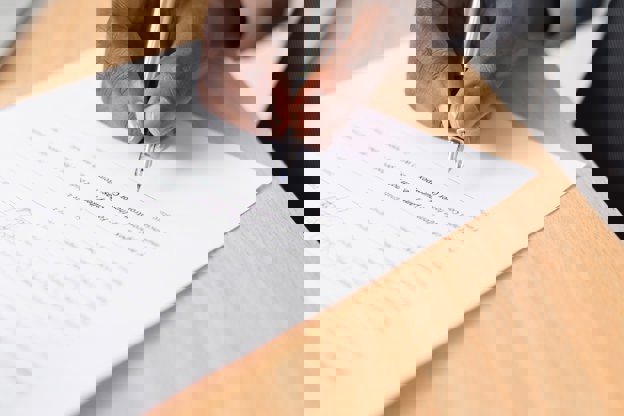 Person signing a piece of paper