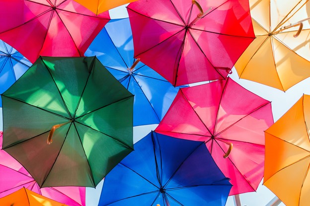 Multicoloured umbrellas overlapping in the sky