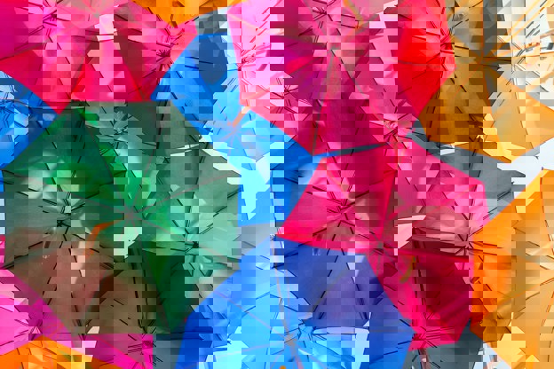 Multicoloured umbrellas overlapping in the sky