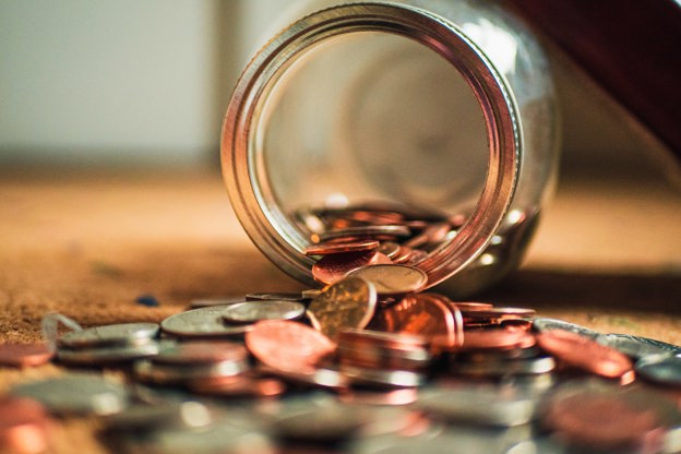 UK money falling out of a glass jar