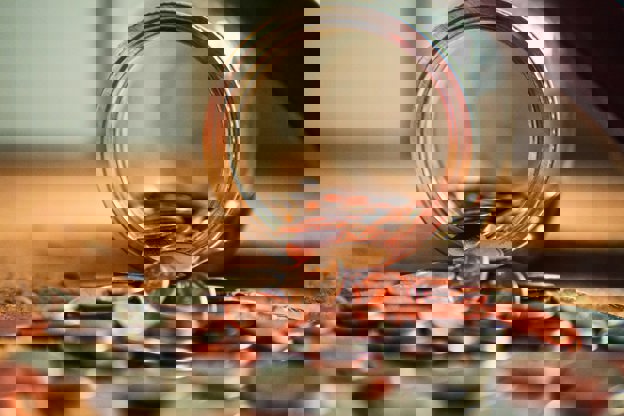 UK money falling out of a glass jar