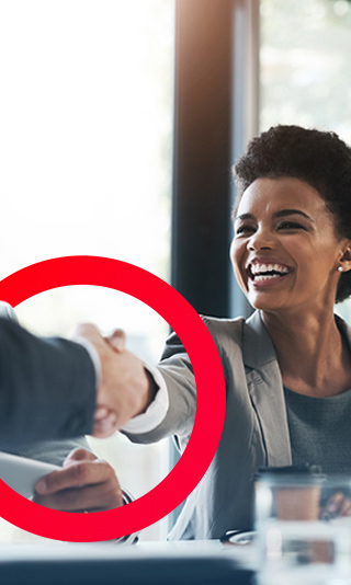 Woman smiling and shaking hands with a male