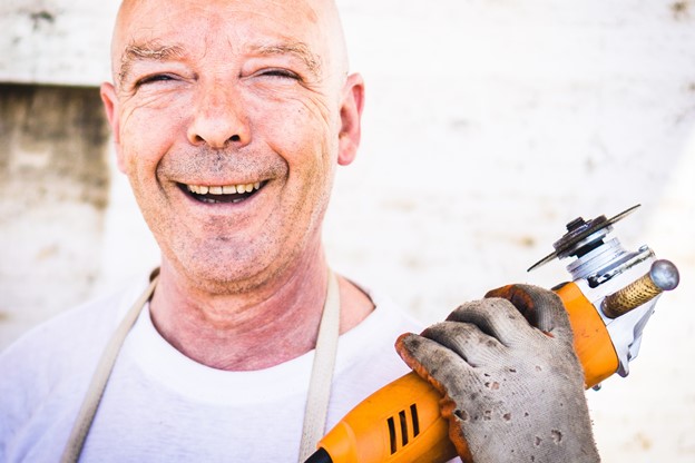 Happy construction worker holding a hand tool