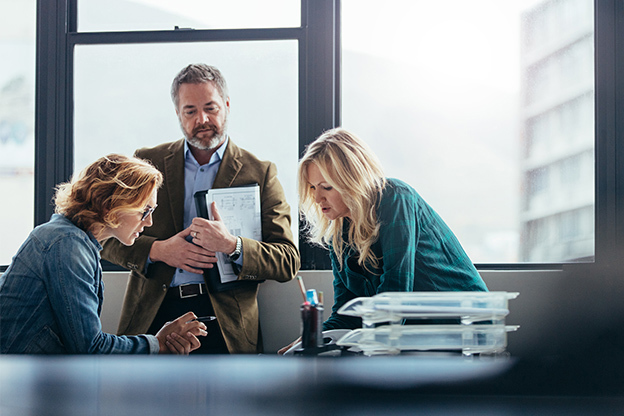 Three office professionals in a meeting discussion