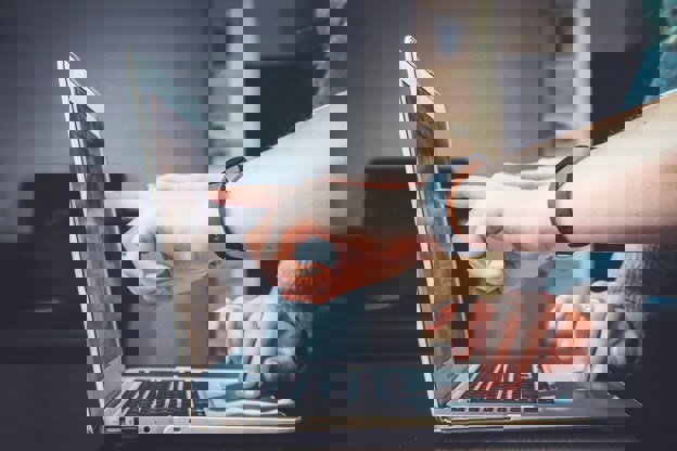 Two people pointing to a laptop screen