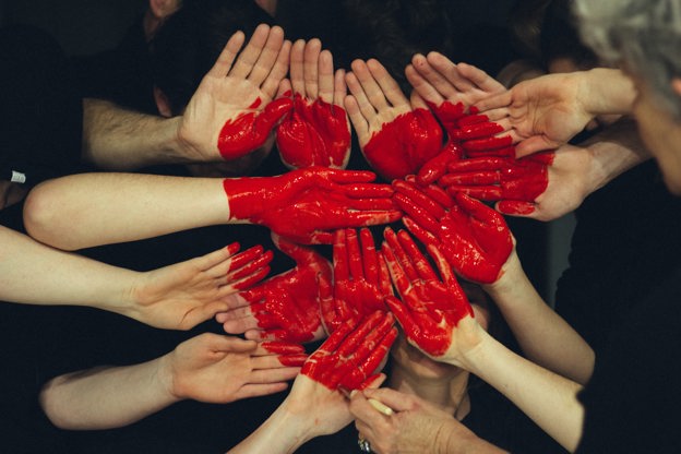 Various peoples hands all painted and held to make a heart