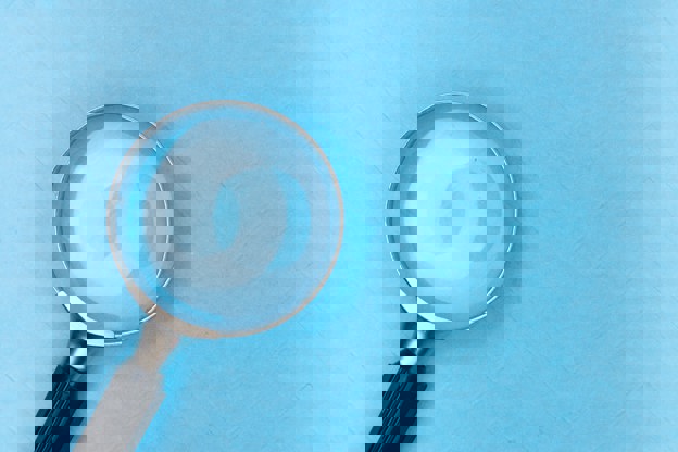 Magnifying glass displayed on sky blue background