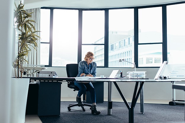 Woman sat at a large desk in an office